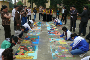 Các em học sinh khối THCS tham dự nội dung thi vẽ tranh trên nền sân xi-măng. 

