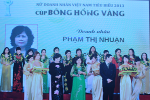 Bà Phạm Thị Nhuận (áo dài xanh đứng giữa, hàng đầu tiên) đón danh hiệu nữ doanh nhân Việt Nam nhận cúp Bông hồng vàng năm 2013.