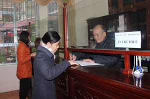 Cán bộ Chi cục Thuế huyện Mai Châu tận tình hướng dẫn người dân làm thủ tục kê khai thuế.

