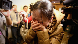 Người thân của hành khách đi trong chuyến bay MH370 đang ở sân bay Bắc Kinh -  Ảnh: Reuters