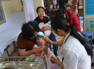 Cán bộ Trạm y tế phường Tân Thịnh (TPHB) tiêm vắc xin cho trẻ trong chương trình TCMR.