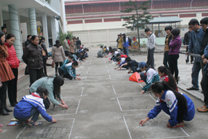 Các thí sinh tham gia thi vẽ tranh trên nền sân xi măng.