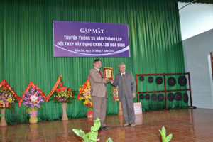 Đại diện Hội cựu TNXP tỉnh tặng biểu tượng TNXP đường 12B cho lãnh đạo UBND huyện Kim Bôi.
