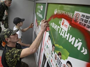 Người biểu tình phun sơn vào logo của ngân hàng Sberbank.