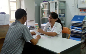 Anh Trương Quang Hưng trao đổi tài liệu tuyên truyền cùng bác sỹ Nguyễn Thị Thành tại phòng khám ngoại trú, khoa truyền nhiễm Bệnh viện Đa khoa tỉnh.

