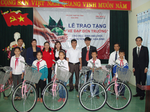 Đại diện công ty Prudential và Hội Chữ thập đỏ tỉnh trao xe đạp cho các em học sinh nghèo học sinh giỏi của huyện Yên Thủy.

