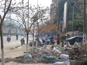 Phế thải xây dựng đổ bừa bãi trên vỉa hè trên đường Trần Hưng Đạo khu vực gần cổng BHXH thành phố. Ảnh chụp lúc 8h40 ngày 1/4