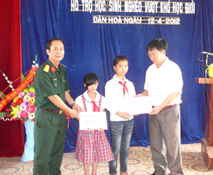 Lãnh đạo Ban CHQS huyện và Công ty INT (Kỳ Sơn) trao học bổng cho học sinh ngèo vượt khó xã Dân Hòa.