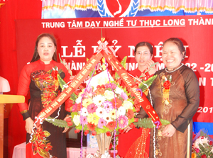 Bà Hoàng Diệu Tuyết, Phó Chủ tịch Hội Bảo trợ Người tàn tật, trẻ mồ côi Việt Nam tặng hoa chúc mừng Trung tâm dạy nghề tư thục Long Thành.