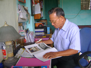 Ông Nguyễn Văn Sính và quyển album ảnh Bác do chính ông sưu tầm.