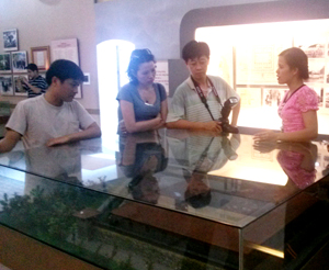 Hướng dẫn viên Bảo tàng tỉnh Sơn La giới thiệu cho khách thăm quan về những hiện vật lịch sử trưng bày tại bảo tàng.