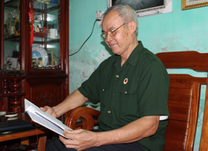 Ông Sản xem lại cuốn nhật ký chiến trường để chuẩn bị cho bài nói chuyện về truyền thống của quân đội nhân dân Việt Nam.