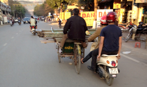 Xe máy đẩy xe xích lô chở hành cồng kềnh gây cản trở giao thông trên đường Cù Chính Lan (TP Hòa Bình). ảnh: ĐP