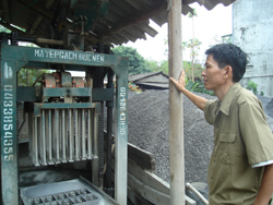 Anh Đinh Gia Tài đang kiểm tra chất lượng sản phẩm gạch không nung trước khi xuất xưởng