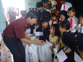 Đồng chí Bùi Văn Cửu, Phó Chủ tịch UBND tỉnh trao quà cho các cháu thiếu nhi xã Toàn Sơn.
