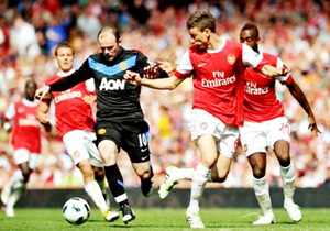 Tiền đạo Rooney (áo đen, Man.United) cố gắng đi bóng trước hàng phòng ngự Arsenal.
