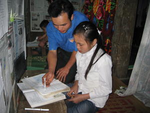 Hà Văn Thương, thành viên đội cờ đỏ xóm Dồ hướng dẫn các em làm bài tập khó. 

