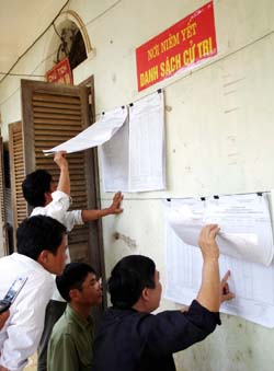 Người dân xã Mỵ Hòa (Tân Lạc) quan tâm theo dõi danh sách niêm yết cử tri. (Ảnh: Mạnh Hùng)