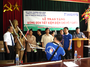 Đại diện Sở Công thương và Công ty Philips Việt Nam trao tặng bóng đèn tiết kiệm điện cho hộ nghèo xã Thung Nai (Cao Phong).