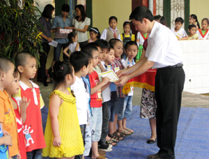 Lãnh đạo Nhà thiếu nhi tỉnh trao giấy chứng nhận hoàn thành chương trình mầm non cho các em lớp 5 tuổi.