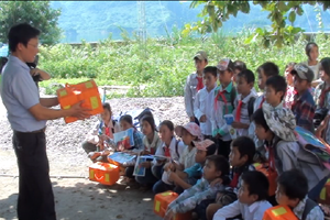Ban ATGT tỉnh tặng và hướng dẫn học sinh trường THCS xã Tiền Phong (Đà Bắc) sử dụng phao cá nhân trên đường thủy. Ảnh: H.H

