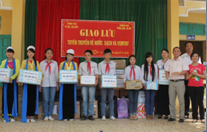 Đại diện Trung tâm Nước sạch và VSMT nông thôn tỉnh và trường THCS Thăng Long tặng quà cho các bạn học sinh trường THCS Tú Sơn.