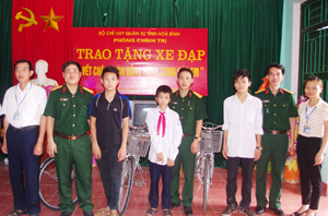 Đại diện lãnh đạo phòng Chính trị - Bộ CHQS tỉnh tặng 3 chiếc xe cho các em học sinh nghèo có hoàn cảnh khó khăn ở xã Dân Chủ (TPHB).