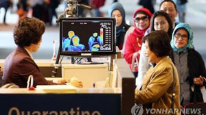 Một quan chức kiểm dịch kiểm tra các dấu hiệu bệnh sốt đối với các hành khách tới sân bay quốc tế Incheon của Hàn Quốc, ngày 21-5-2015. (Ảnh: Yonhap)