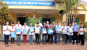 Đại diện lãnh đạo Báo Hà Nội Mới và Đoàn thanh niên hai báo tặng quà cho các em học sinh nghèo vượt khó trường THCS Nguyễn Bá Ngọc.