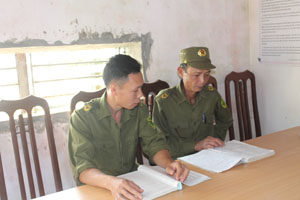 Anh Trần Thái Thành (bên trái) thường xuyên trao đổi kinh nghiệm tuyên truyền, vận động với công an viên các xóm, thôn.