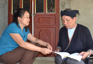 Cán bộ MTTQ xã Toàn Sơn (Đà Bắc) trao đổi, chia sẻ  các văn bản mới về công tác bầu cử  với già làng Triệu Văn Hội, xóm Cha.