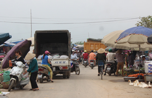 Né trạm thu phí, xe tải chở hàng len lỏi đi qua khu vực chợ thị trấn Lương Sơn (Lương Sơn).
