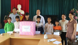 Đại diện huyện ủy, UBND huyện Tân Lạc tặng quà cho các em Tiểu học Bắc Sơn.