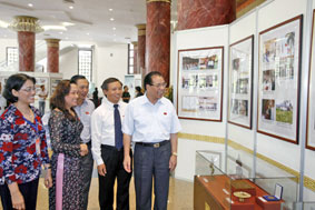Tổng Bí thư Nông Ðức Mạnh và các
đại biểu xem một số hình ảnh và
hiện vật tại triển lãm.
