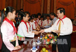 Chủ tịch nước Nguyễn Minh Triết tặng quà cho các em thiếu nhi.
 Ảnh: TTXVN
