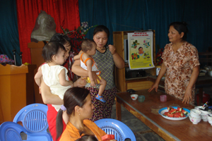 Cán bộ y tế thôn, bản phường Thịnh Lang (TPHB) tư vấn nấu cháo dinh dưỡng cho các bà mẹ.