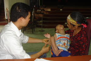 Bác sĩ Trung tâm Kỹ thuật chỉnh hình và Phục hồi chức năng Sơn Tây (Hà Nội) khám cho trẻ bị bại não huyện Lương Sơn.