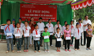 Đại diện Sở, ngành, huyện Kỳ Sơn trao quà cho học sinh nghèo đạt thành tích cao trong học tập.
