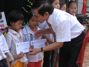 Đồng chí Quách Thế Tản, Chủ tịch Hội Khuyến học tỉnh trao quà của Công ty Hoàng Sơn cho học sinh nghèo vượt khó tại xã Cố Nghĩa (Lạc Thủy).