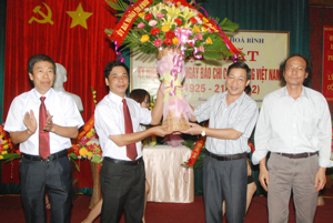 Đồng chí Bùi Văn Cửu, Phó Chủ tịch TT UBND tỉnh trao tặng lẵng hoa của Tỉnh uỷ, HĐND, UBND, UBMTTQ tỉnh chúc mừng các nhà báo.