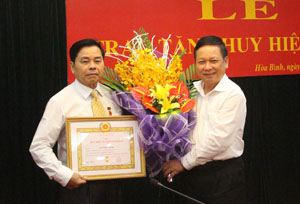 Đồng chí Bùi Văn Tỉnh, Ủy viên BCH T.Ư Đảng, Bí thư Tỉnh ủy trao Huy hiệu Đảng và tặng hoa chúc mừng đồng chí Đinh Đăng Lượng

