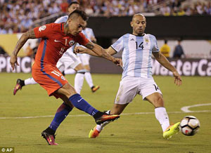Tiền đạo Eduardo Vargas tung cú sút trước Javier Mascherano của Argentina.