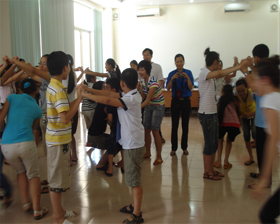 Các em thiếu niên, nhi đồng cùng tham gia trò chơi với các thanh niên Singapore.