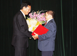 Bộ trưởng Bộ GD-ĐT Phạm Vũ Luận (bên trái) tặng hoa Thứ trưởng Bùi Văn Ga