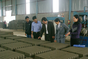 CCB Đinh Ý Quỳnh (đứng giữa), xã Mông Hoá (Kỳ Sơn) giới thiệu sản phẩm gạch bêtông công nghệ cao do Công ty làm ra.