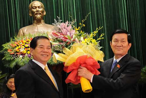 Nguyên chủ tịch nước Nguyễn Minh Triết (trái) trao hoa chúc mừng tân Chủ tịch nước Trương Tấn Sang.