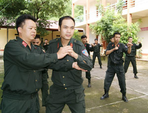 Đại úy Bạch Công Thắng (trái) hướng dẫn chiến sĩ trong đơn vị luyện tập võ thuật.