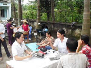 Cán bộ Trung tâm DS-KHHGĐ huyện khám bệnh, cấp thuốc miễn phí cho người dân xã Nhuận Trạch.