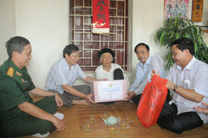 Đồng chí Bùi Văn Cửu, Phó Chủ tịch TT UBND tỉnh tặng quà cho mẹ Nguyễn Thị Bì, xã Mông Hoá (Kỳ Sơn).