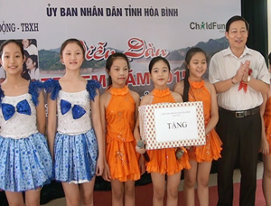 Đồng chí Bùi Văn Cửu, Phó Chủ tịch TT UBND tỉnh, Trưởng ban tổ chức, trao quà cho trẻ em tại diễn đàn.

